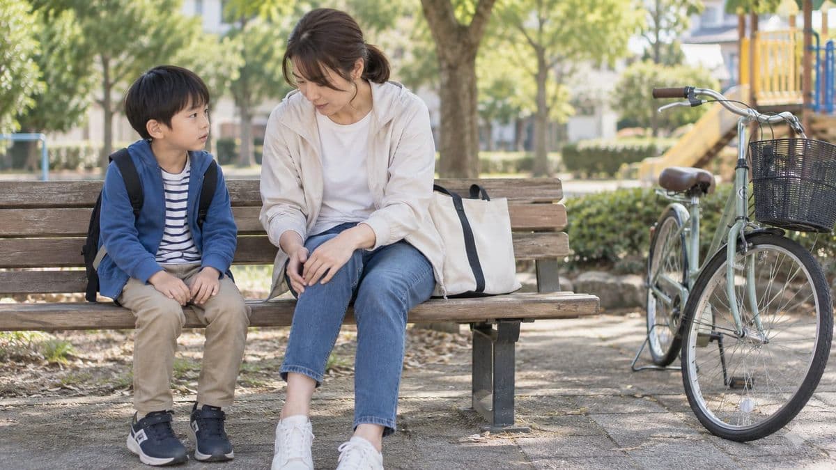自転車転倒後に子どもの腹部の状態を確認する母親